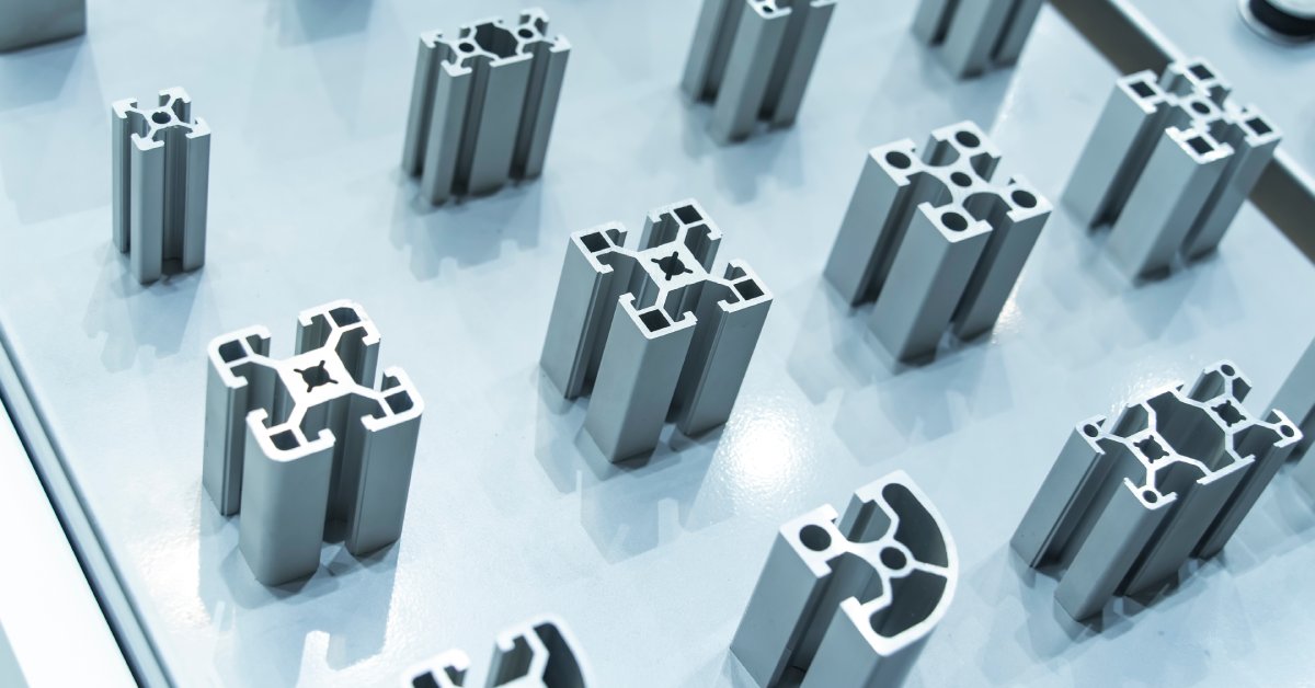 Extruded pieces of aluminum all standing up on a table. All the pieces have a different shape and size.