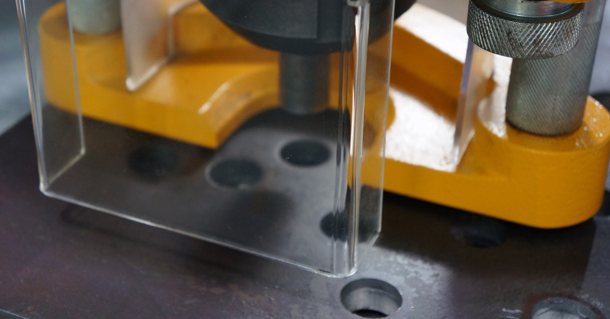 A clear cover protecting workers from the dangerous components of a metal machine in an industrial facility.